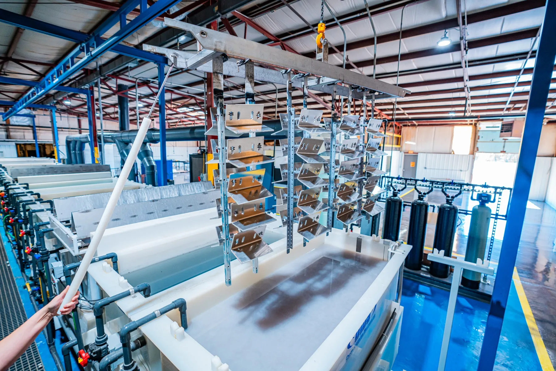 Racked aluminum parts over the anodizing line at the AnoPRO plant in Paoli